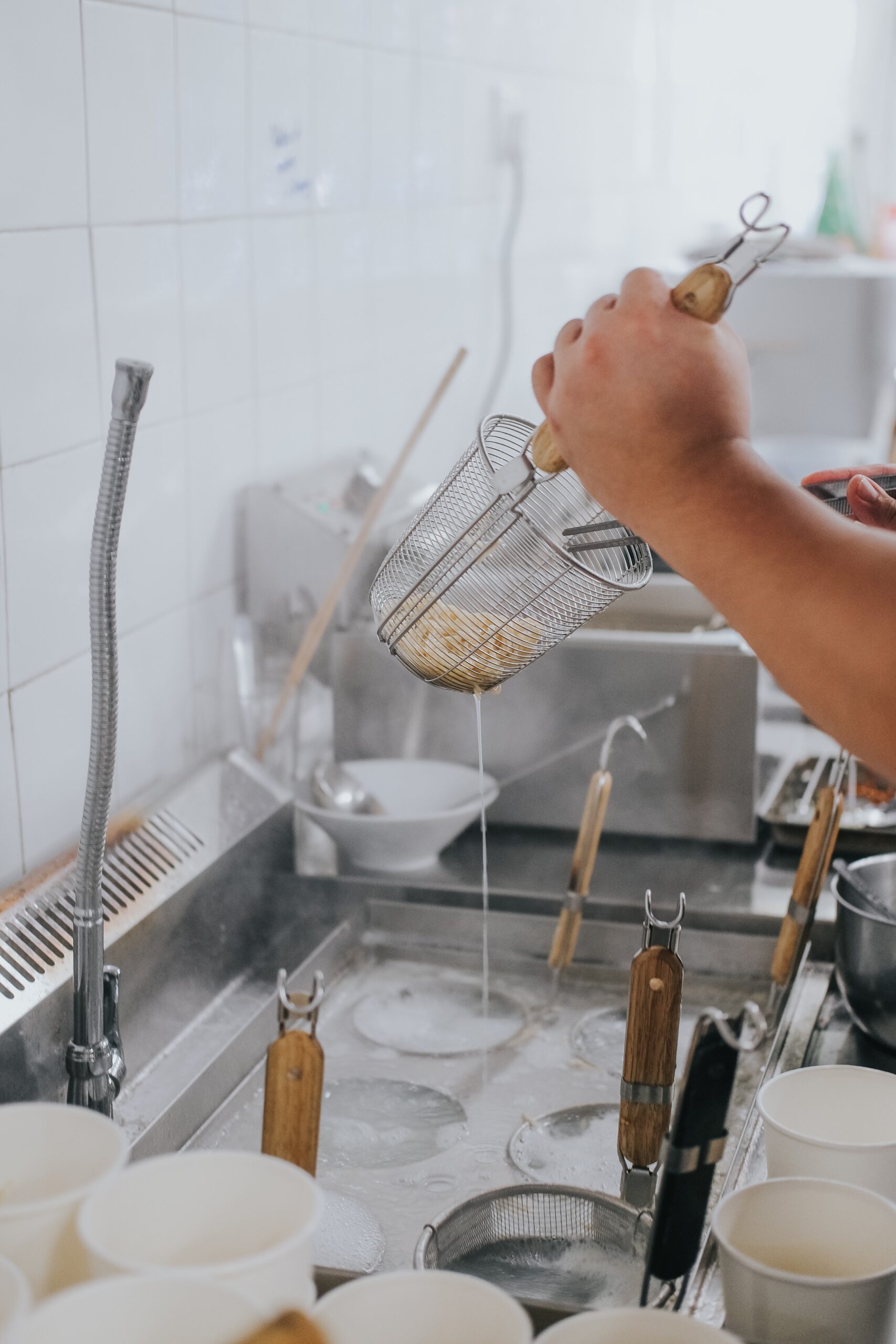 straining food in an industrial kitchen to illustrate how EZ Gluten test kits can be used at industrial kitchens